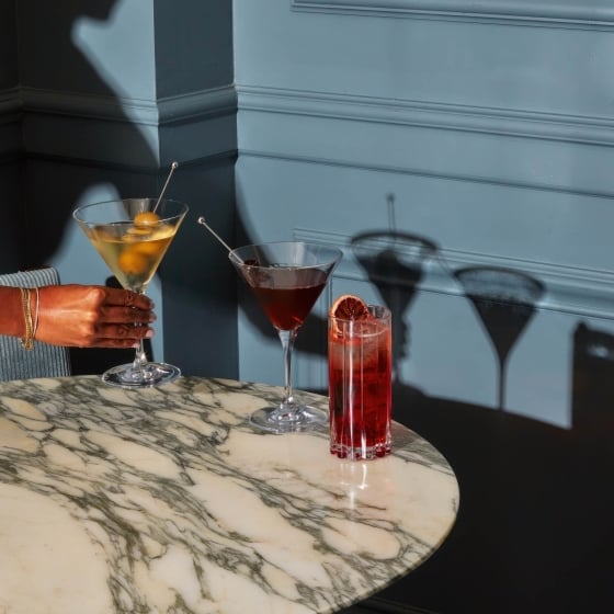 Three assorted cocktails on a marble table.