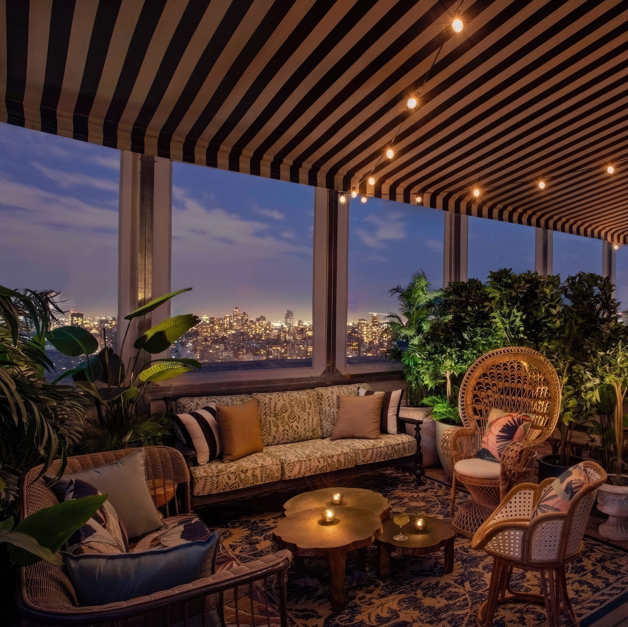 A cozy lounge area with warm lighting at dusk, New York City skyline in the background.