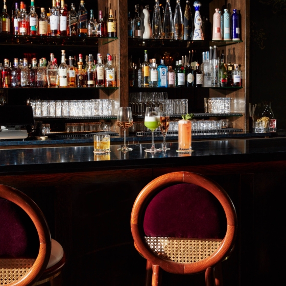 An assortment of cocktails along a bar top.