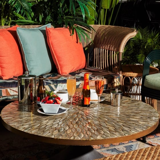 An assortment of drinks and fruit on a warm patio terrace.