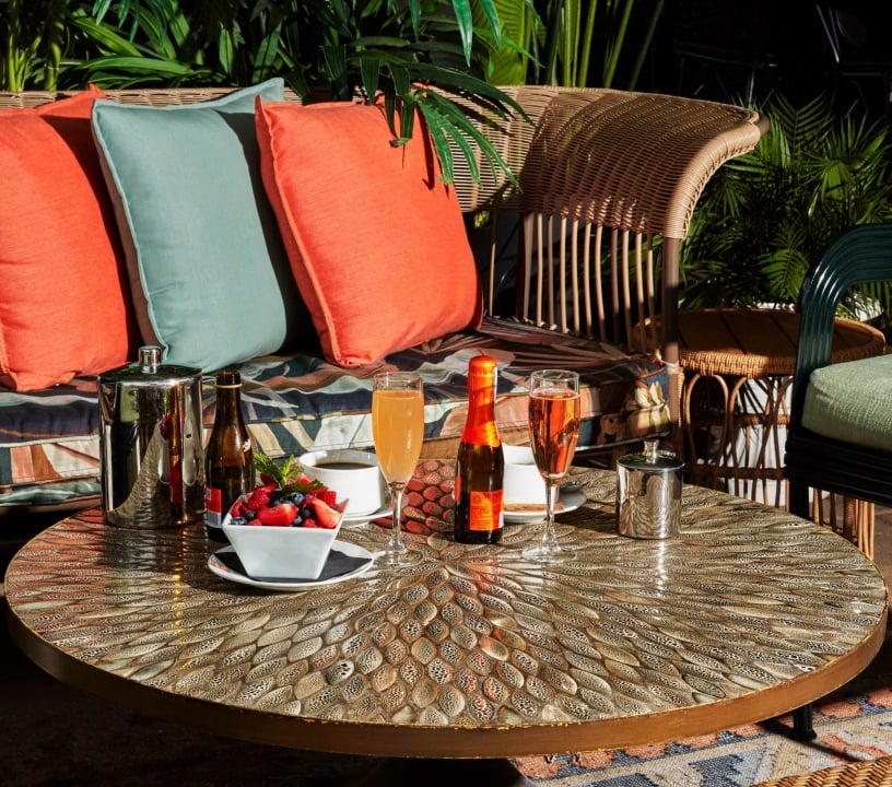 An assortment of drinks and fruit on a warm patio terrace.