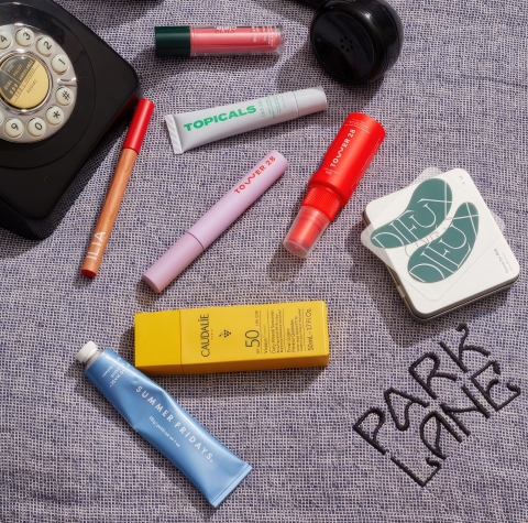 An assortment of beauty products laid out of a blanket embossed with 'Park Lane'.