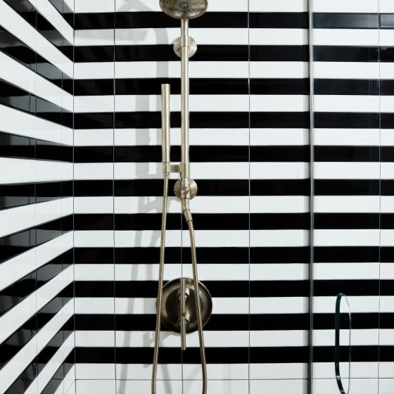 A shower with black and white horizontal striped tiles at Park Lane New York.