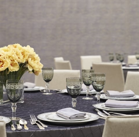 A table set with china, cutlery and glasses for an event.