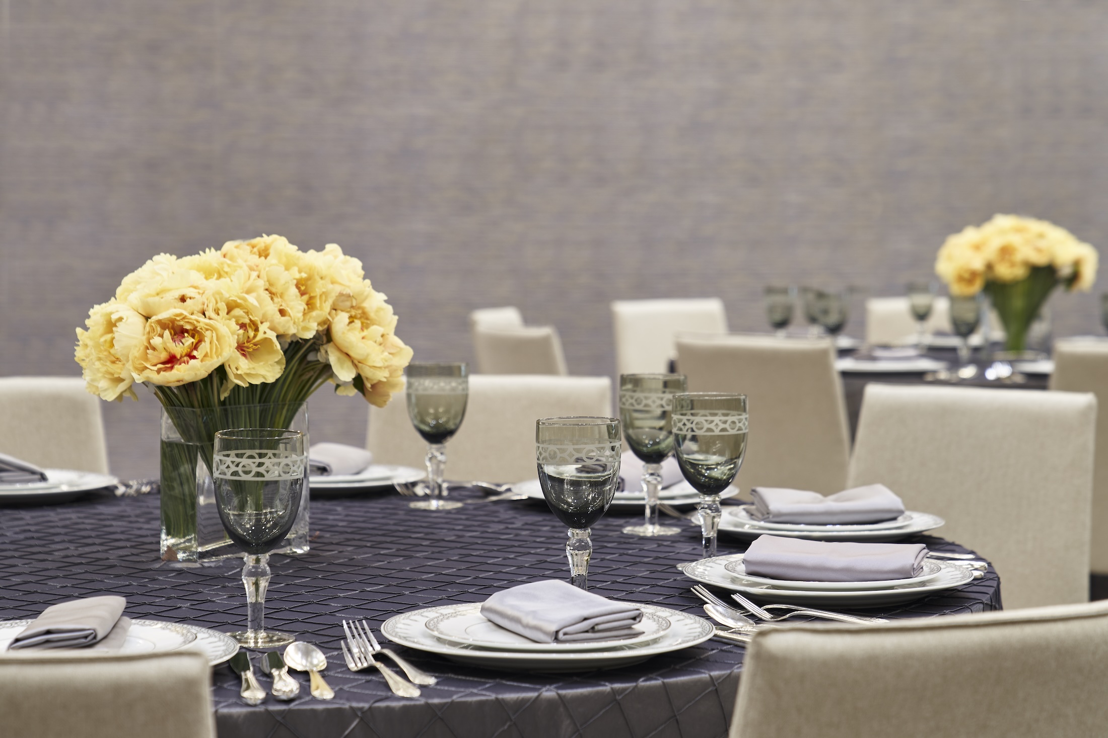 A table set with china, cutlery and glasses for an event.