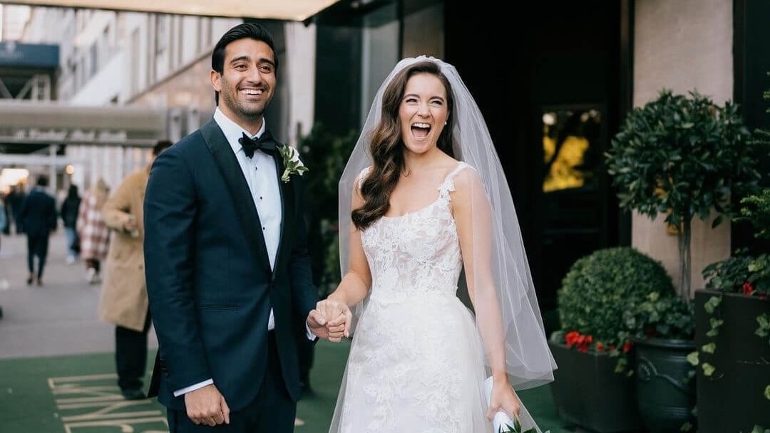 A bride and groom smiling outside of Park Lane.