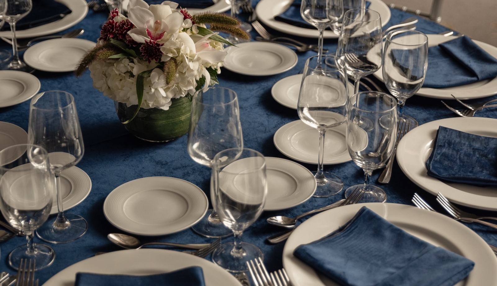 A table set with china, cutlery and glasses for an event.