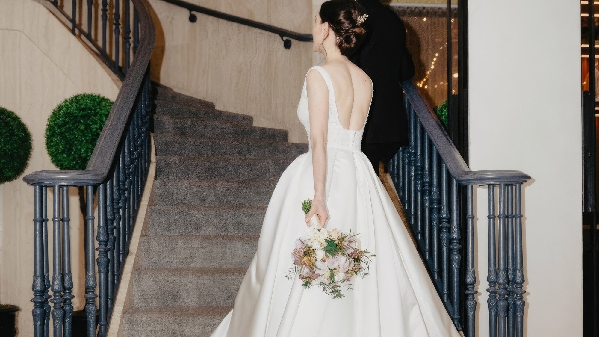 A bride and groom walking up stairs.