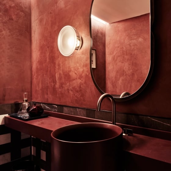 A moody red sink area of the bathroom of the Conservatory Suite at Park Lane New York.