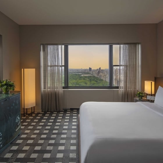 The bedroom with a king bed and panoramic view of Central Park in the Conservatory Suite at Park Lane New York.