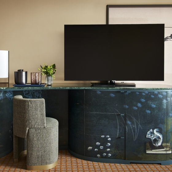 A TV and desk with chair in a suite at Park Lane New York.