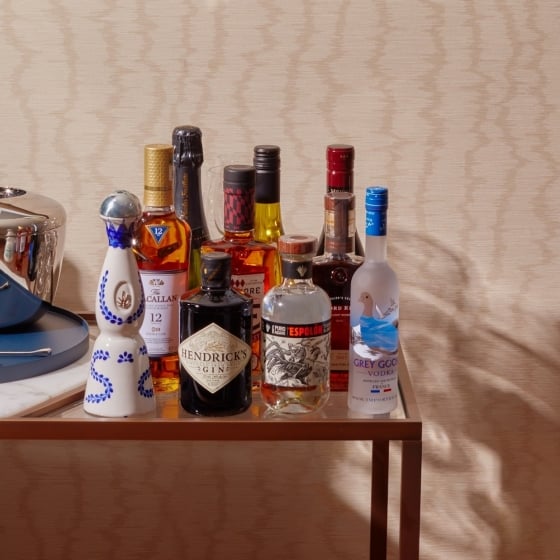 A stocked bar cart with assorted liquors.