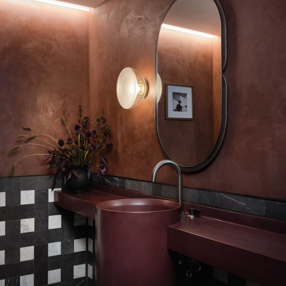 A moody red sink area of the bathroom of a suite at Park Lane New York.