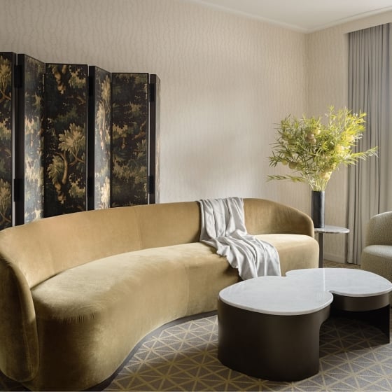 A seating area with couch and chair in a suite at Park Lane New York.