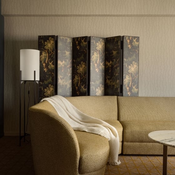 A couch and hand painted room divider in a suite at Park Lane New York.