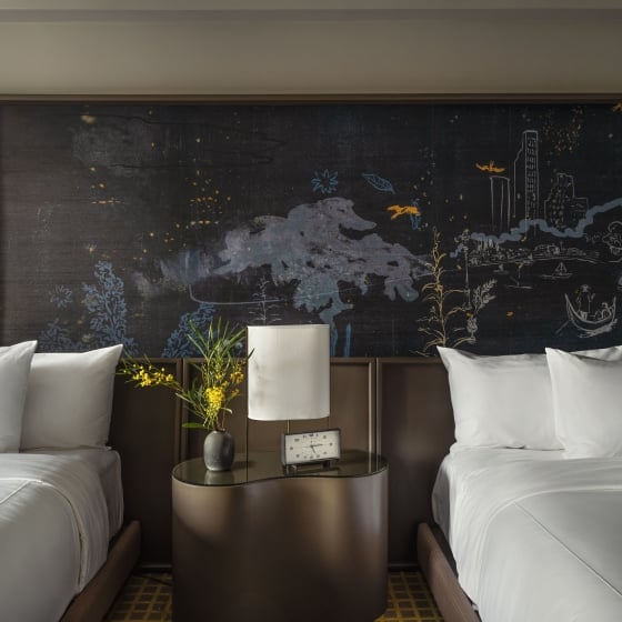 Two queen beds against a hand painted mural at Park Lane New York.