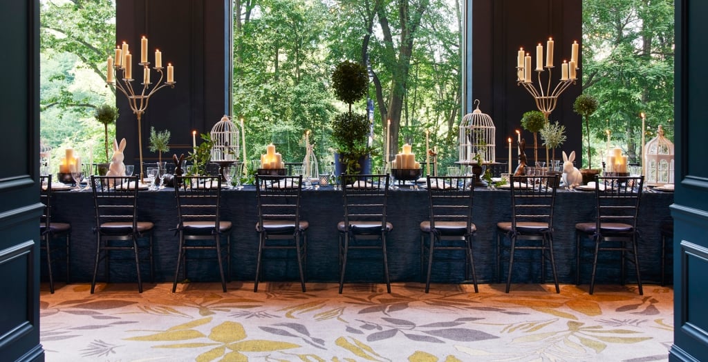 An elegant dining room with views of lush green outside.