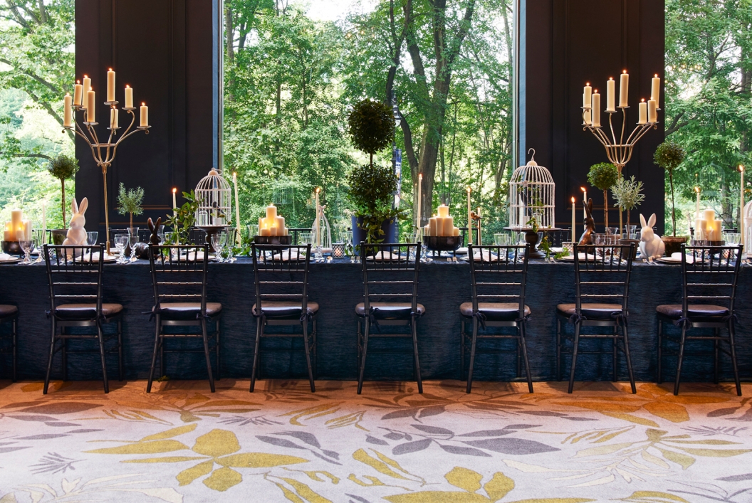 An elegant dining room with views of lush green outside.