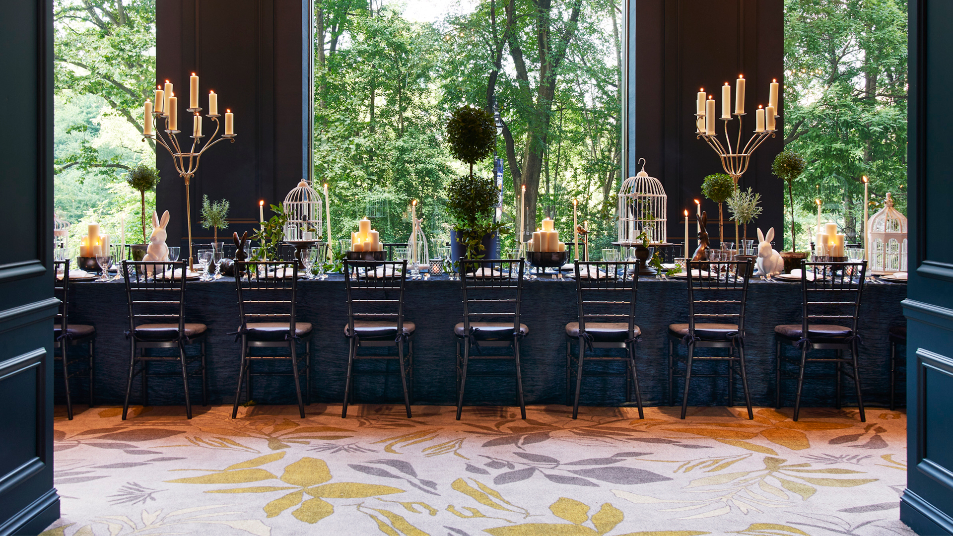 An elegant dining room with views of lush green outside.