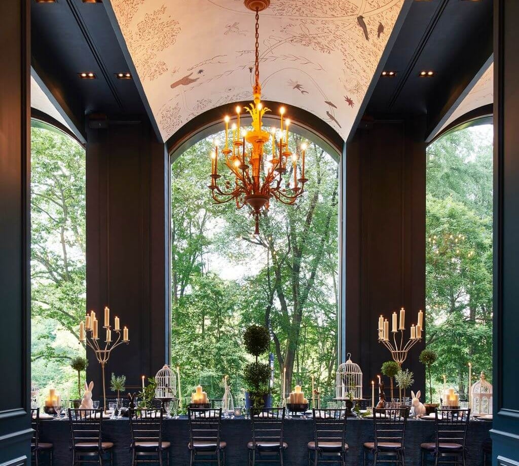 An elegant dining room with views of lush green outside.