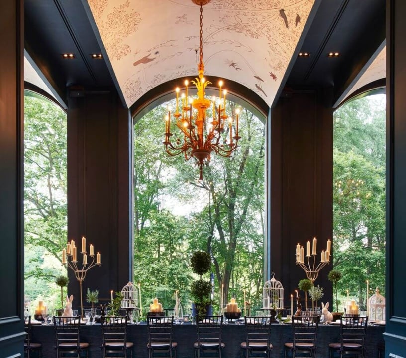 An elegant dining room with views of lush green outside.