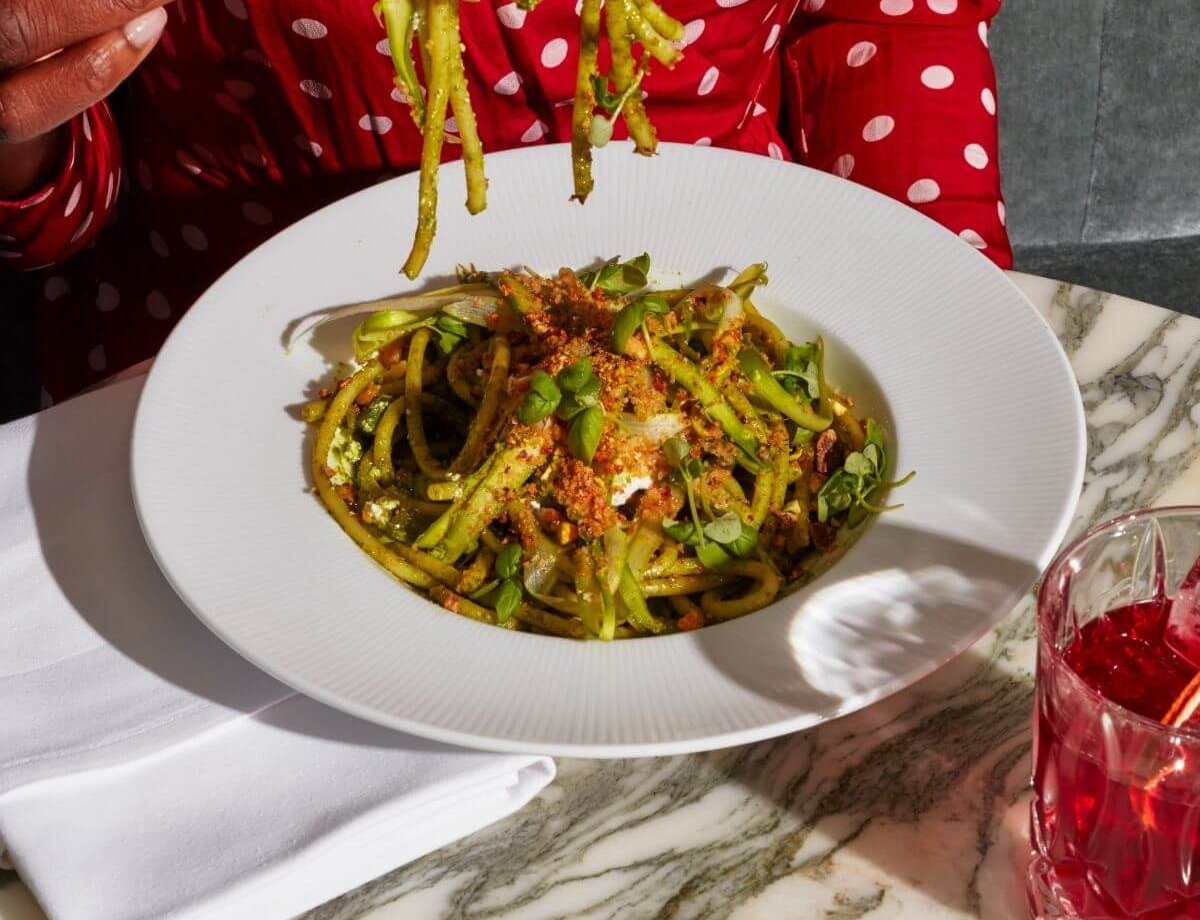 A woman eats a pasta dish.