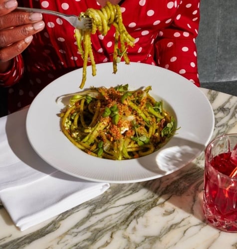 A woman eats a pasta dish.